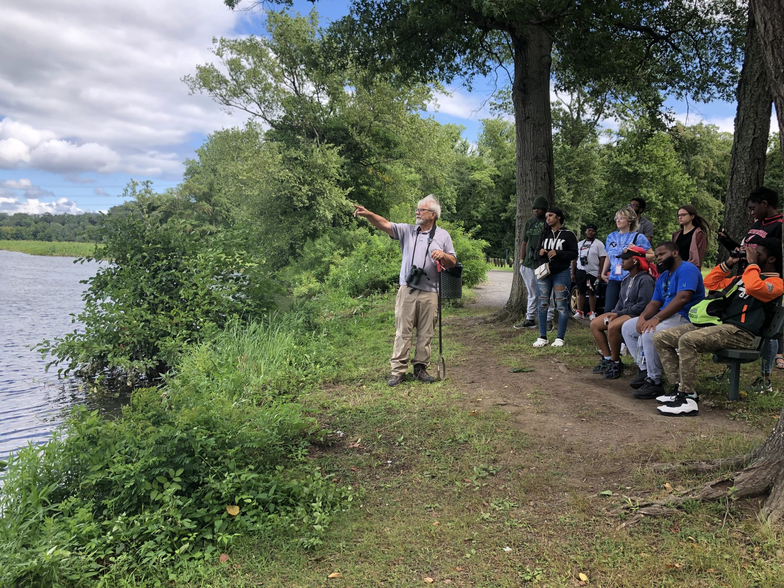 Mark Gallagher of Princeton pointing towards the wetland restoration site at Roebling Park explaining wetland restoration to group of youth